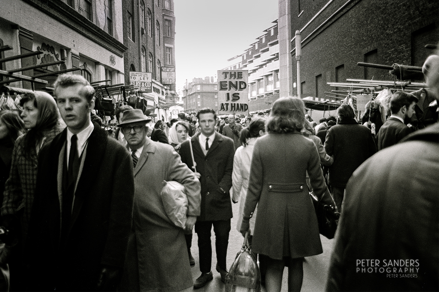 Peter Sander Photos - a crowd of people walking down a street
